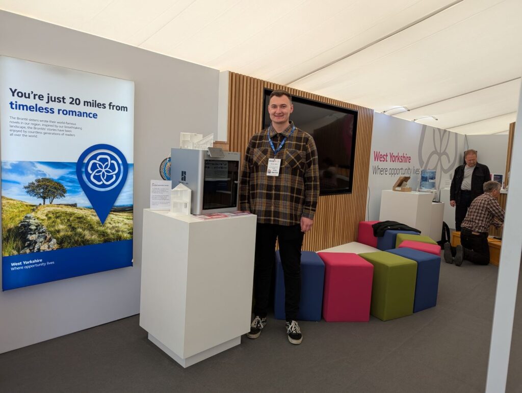 Male stood at an exhibition stand at investment event