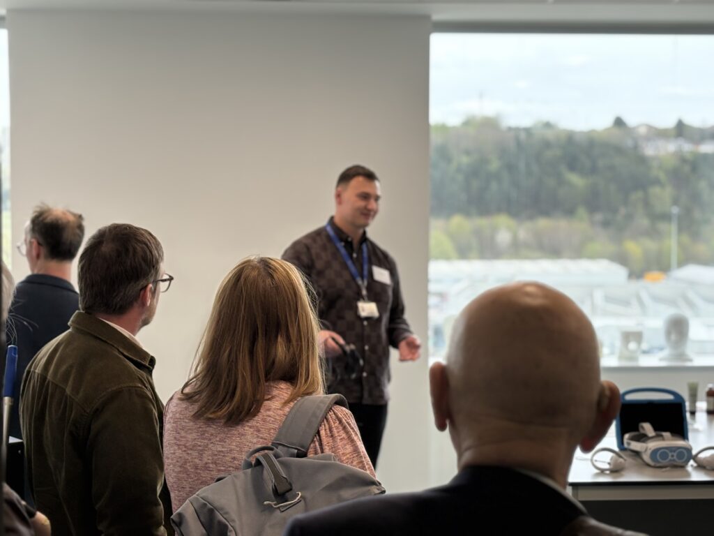 A person stood in front of a group communicating healthcare innovation ideas.