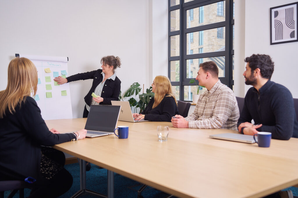 People gathered around a table in a meeting room.